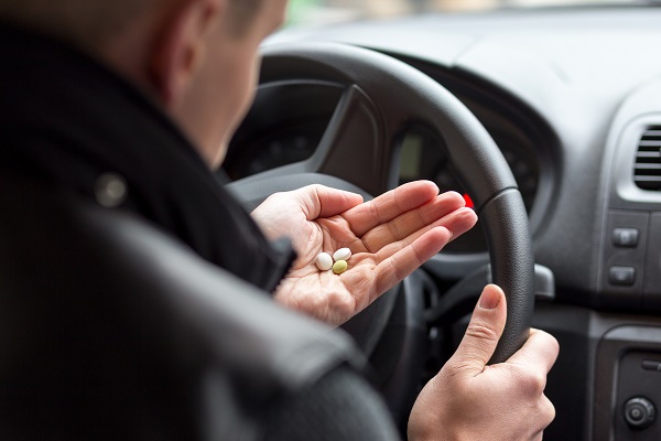 Man taking pills while driving