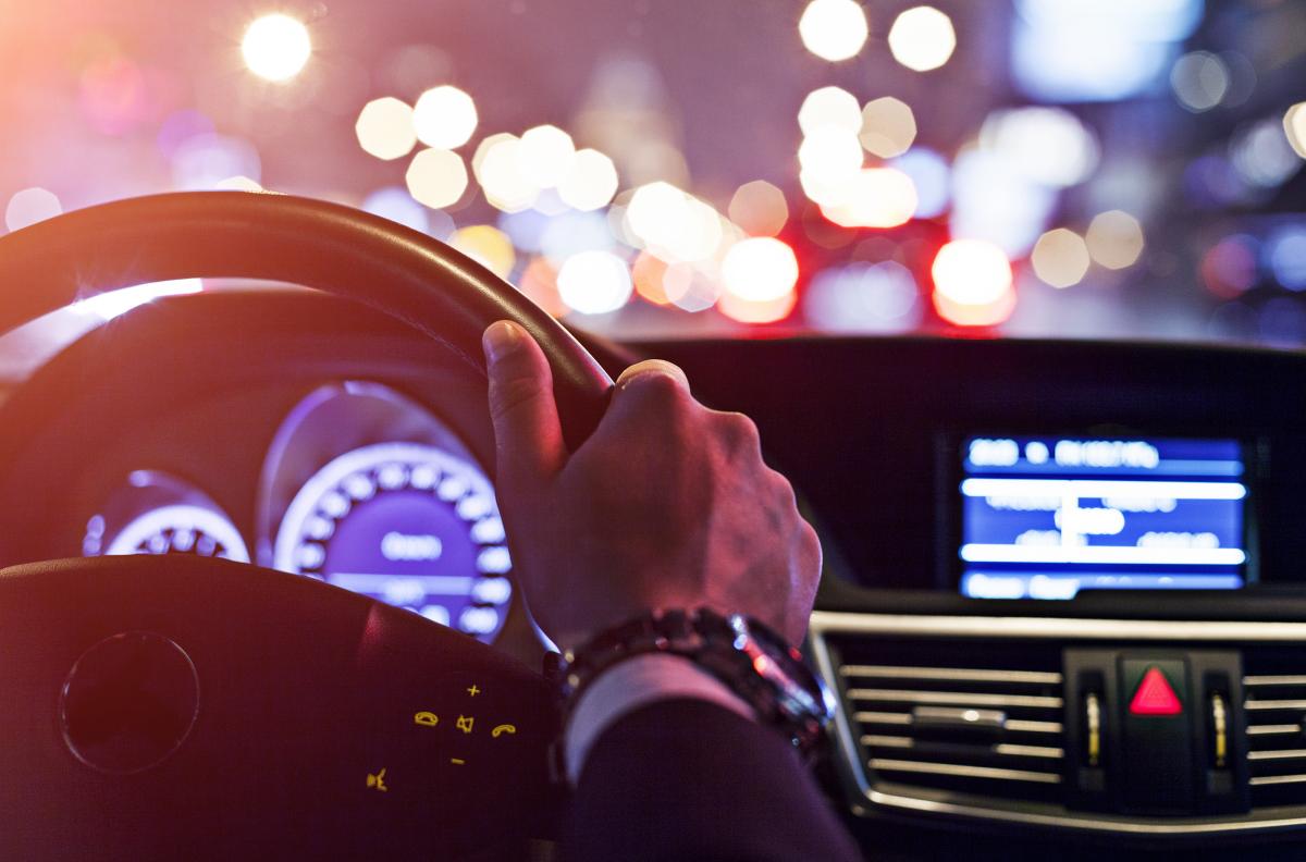 Hand on steering wheel, driving at night