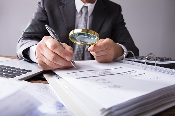 Lawyer looking at books with a magnifying glass