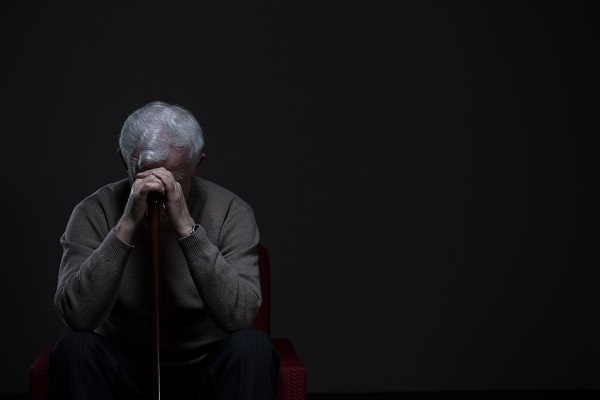 Sad elderly man sitting on a bench