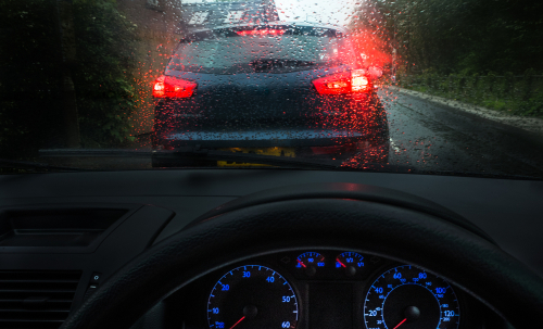 Tailgaiting a car in a moody dark in stormy, wet conditions