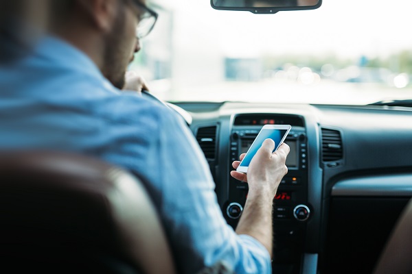 Man texting while driving. Distracted driving.