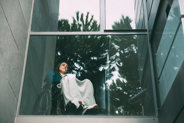 Woman in wheelchair looking out of second floor office window